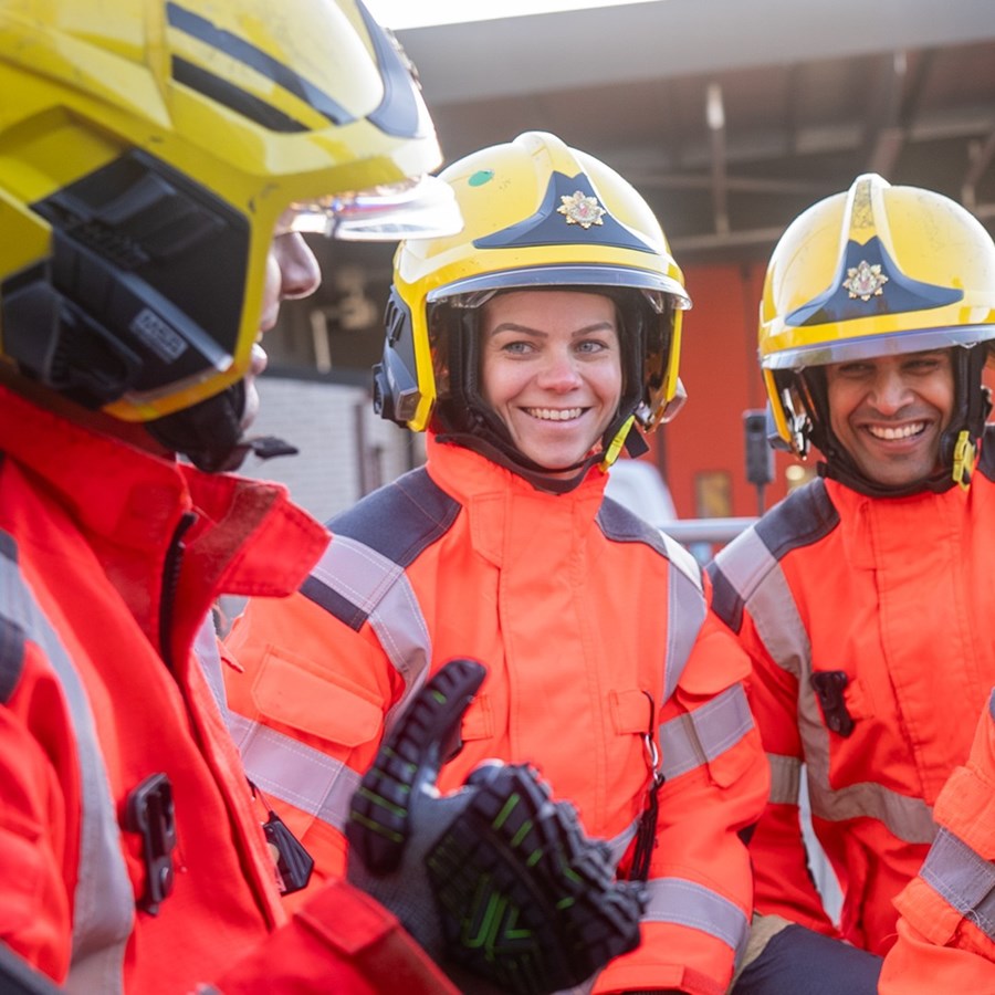 Three firefighters in full uniform.
