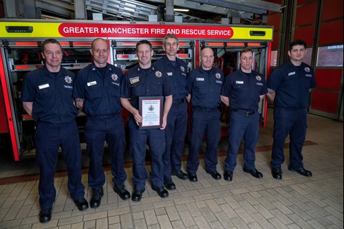 Firefighters stood in a line with their award