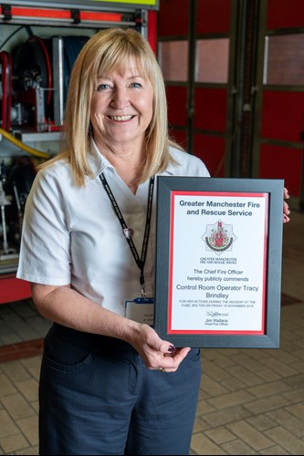 Tracy Brindley holding the commendation she was awarded