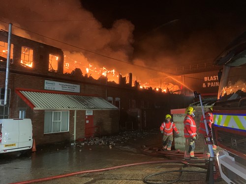 Firefighters on the scene extinguishing fire at industrial unit