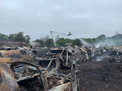 Photograph of burnt out vehicles at the industrial yard