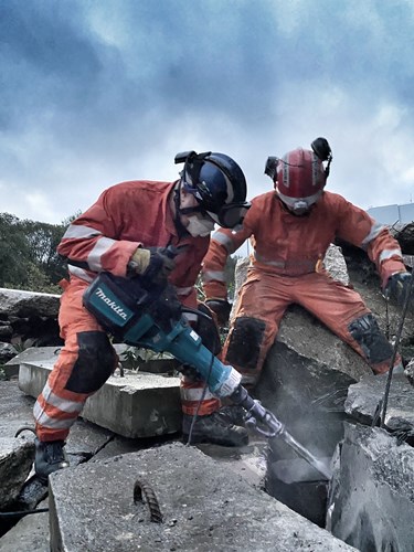 UKISAR personnel use a drill on debris as part of the exercise