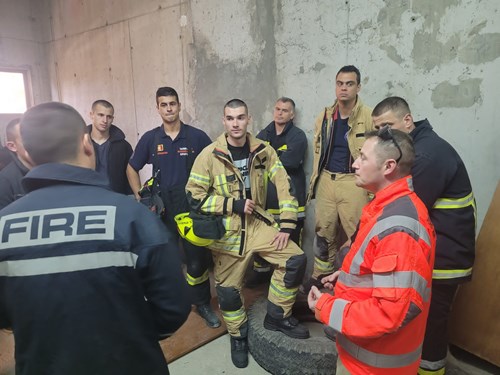 group of firefighters stood in a circle in a training room