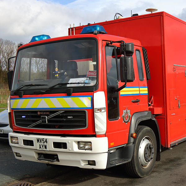 A red fire truck with blue lights parked on a road