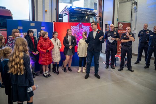 Andy Burnham stood with firefighters and school children in a fire station